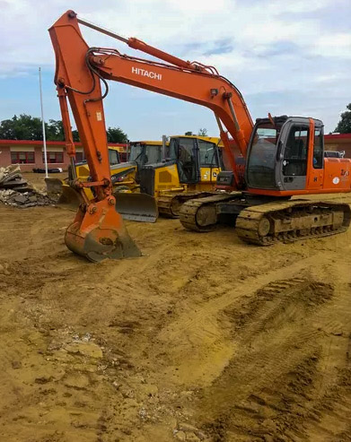 Theodolite, a levelling instrument in the foreground and a crawler loader on construction site leveling ground