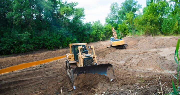 An excavator grading the site for slope correction